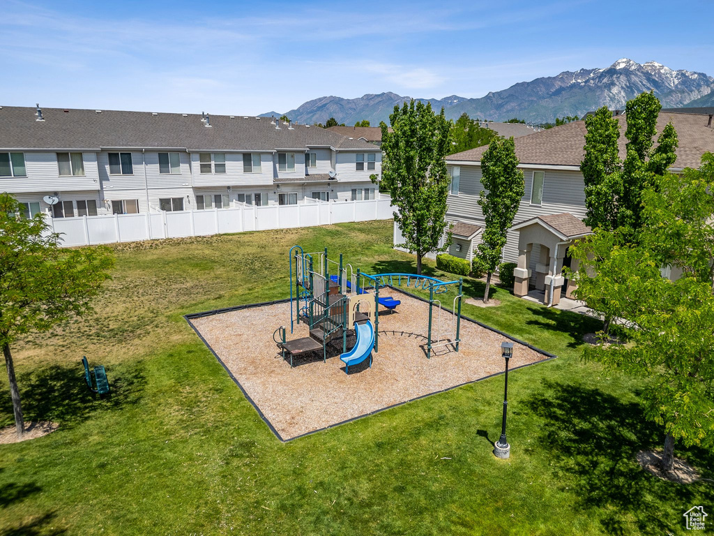 Community playground featuring a mountain view, a lawn, and a residential view