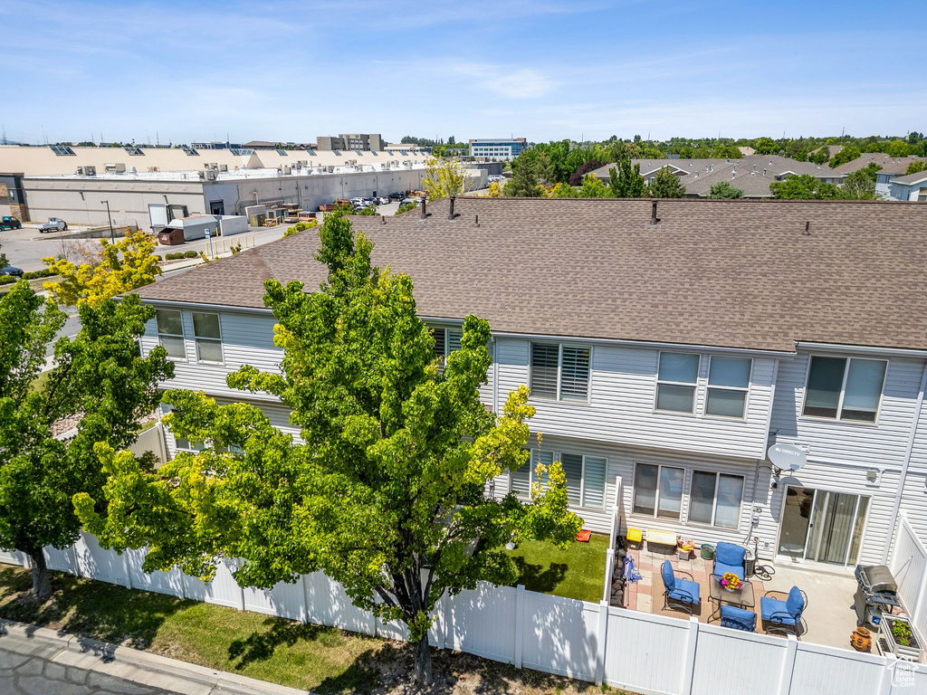 View of front of home with a fenced backyard, a residential view, a patio, and roof with shingles