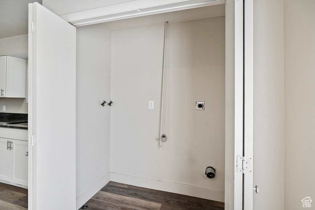Laundry room featuring hookup for an electric dryer, dark wood-type flooring, and baseboards
