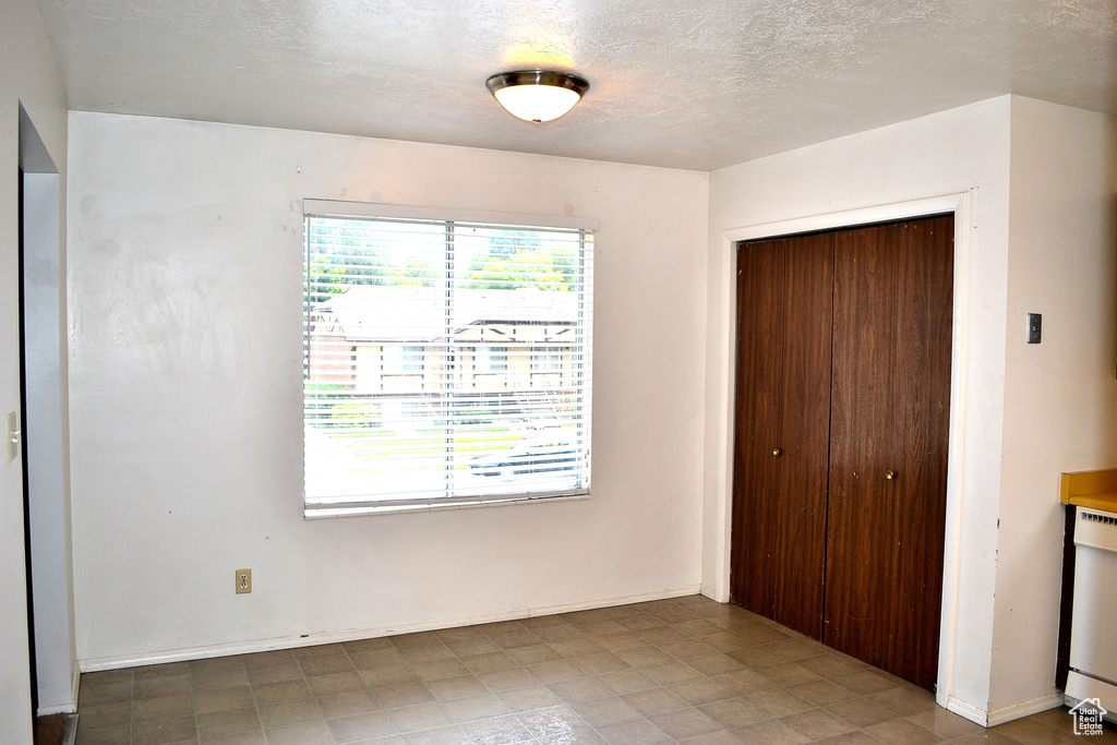 Unfurnished bedroom with a closet and a textured ceiling