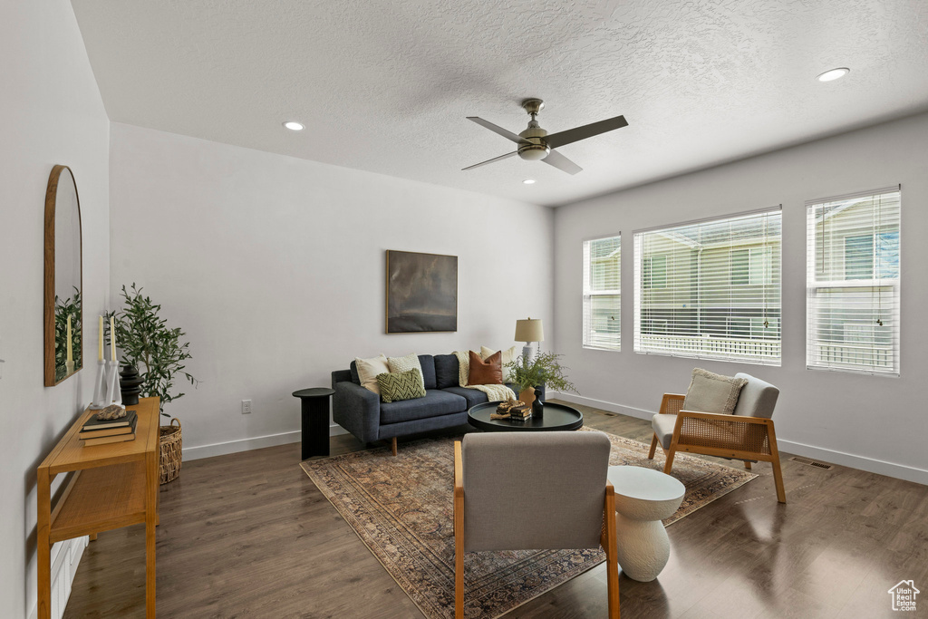Living area featuring ceiling fan, wood finished floors, a textured ceiling, baseboards, and recessed lighting