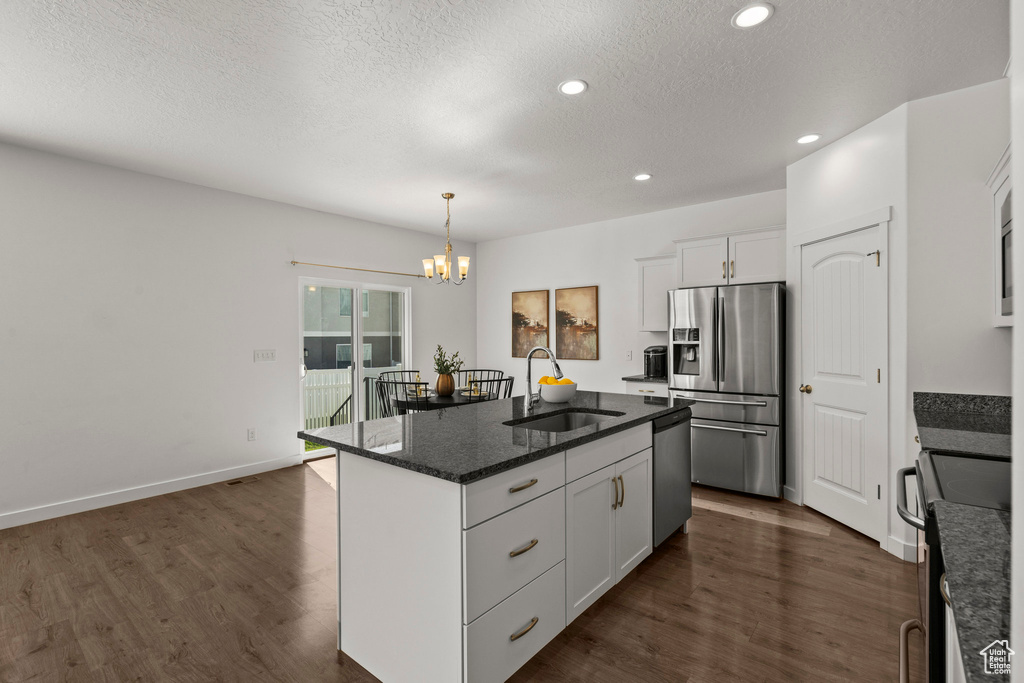 Kitchen featuring appliances with stainless steel finishes, a sink, a chandelier, dark wood-style floors, and recessed lighting