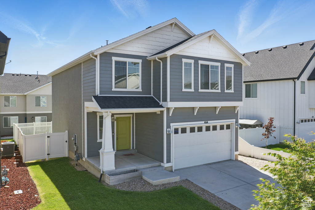 View of front of home with a garage, concrete driveway, central AC, and a shingled roof
