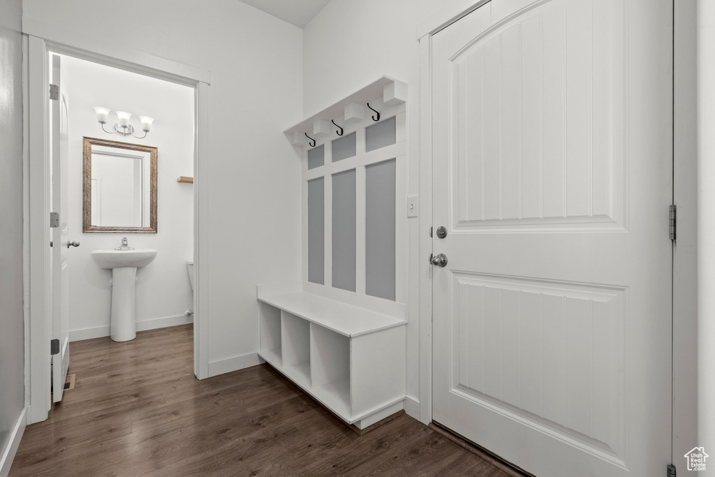 Mudroom with dark wood-style floors, baseboards, a sink, and a chandelier