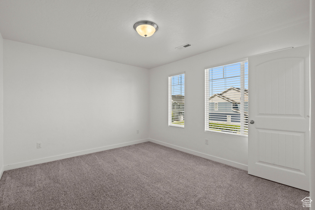 Unfurnished room featuring light colored carpet and baseboards