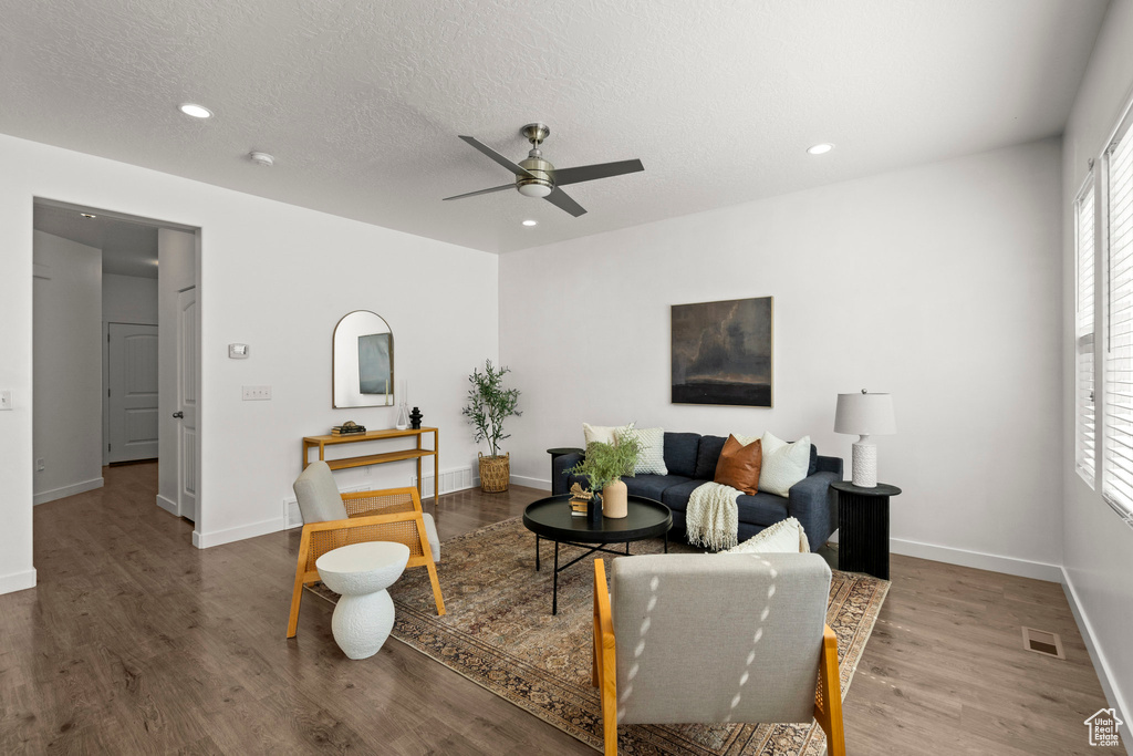 Living room with a ceiling fan, wood finished floors, recessed lighting, healthy amount of natural light, and a textured ceiling