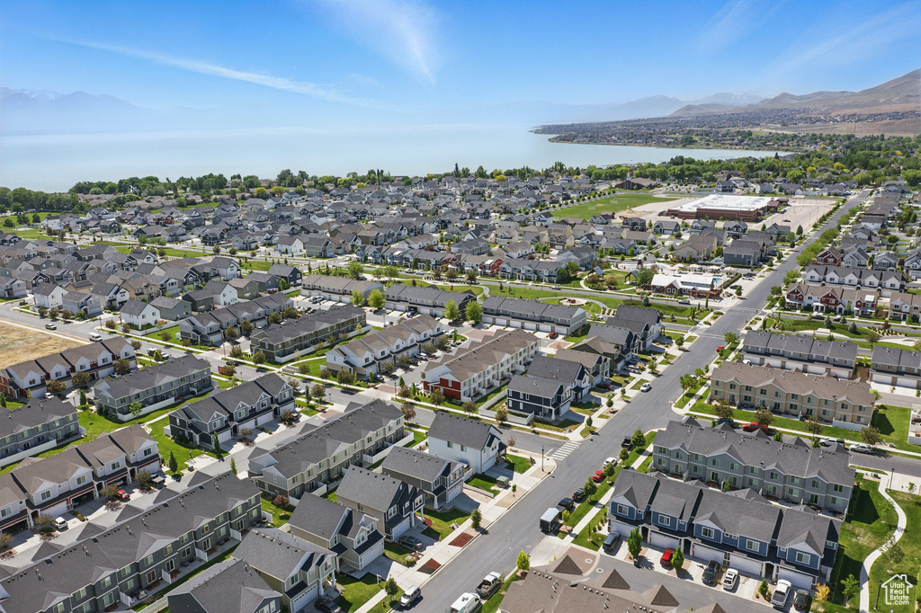 Aerial view of property and surrounding area featuring a water and mountain view and nearby suburban area
