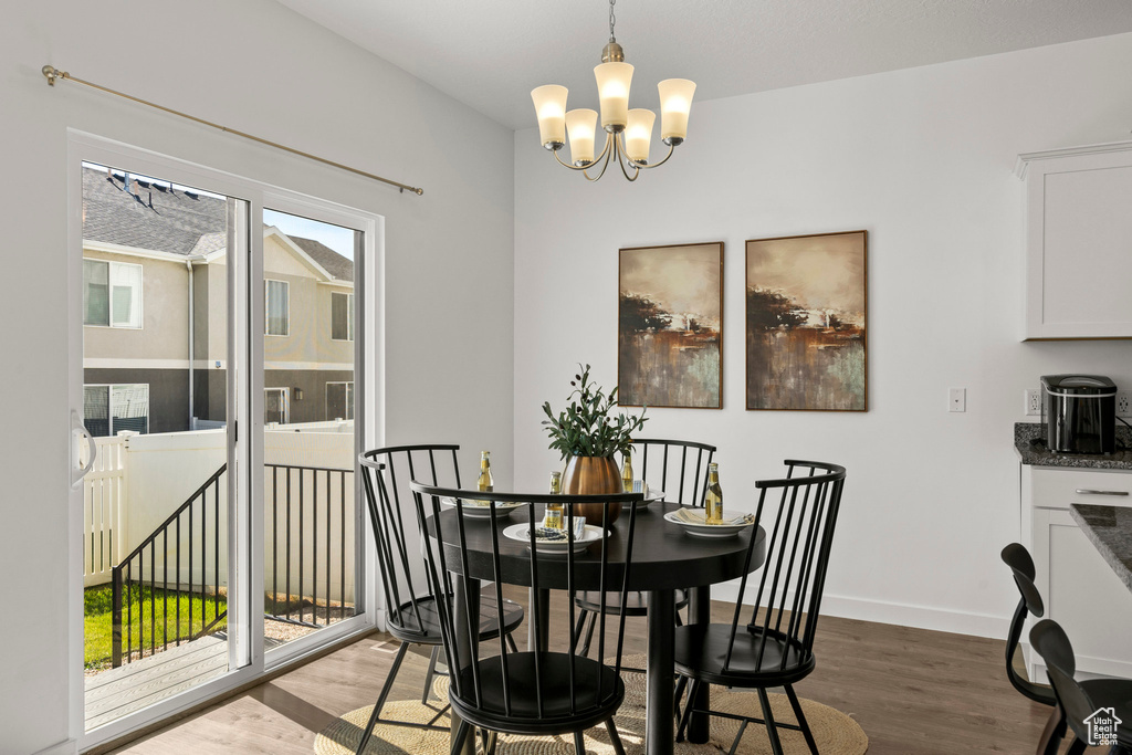 Dining area with a chandelier, light wood-style flooring, and baseboards