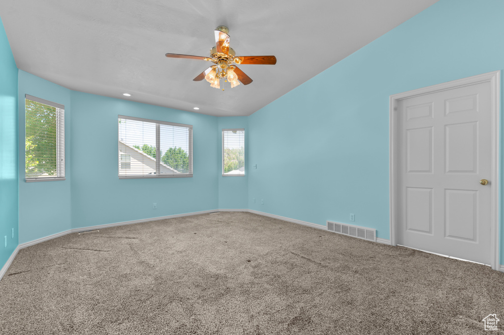 Carpeted empty room with healthy amount of natural light, a ceiling fan, baseboards, and recessed lighting