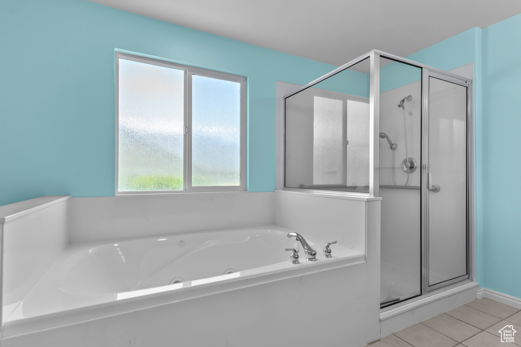 Bathroom featuring a shower stall, a jetted tub, and tile patterned flooring