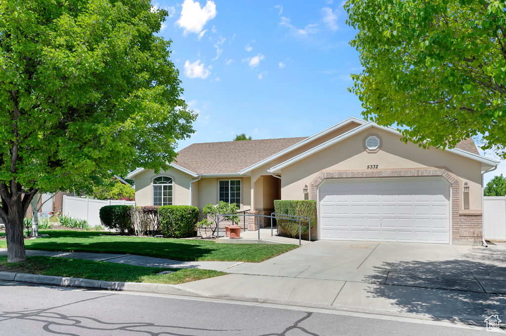 Single story home featuring stucco siding, a garage, concrete driveway, and a shingled roof