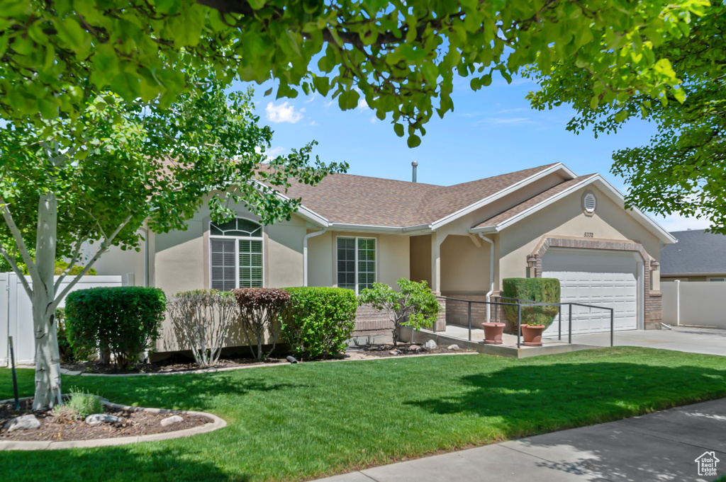 Single story home featuring an attached garage, stucco siding, driveway, and roof with shingles