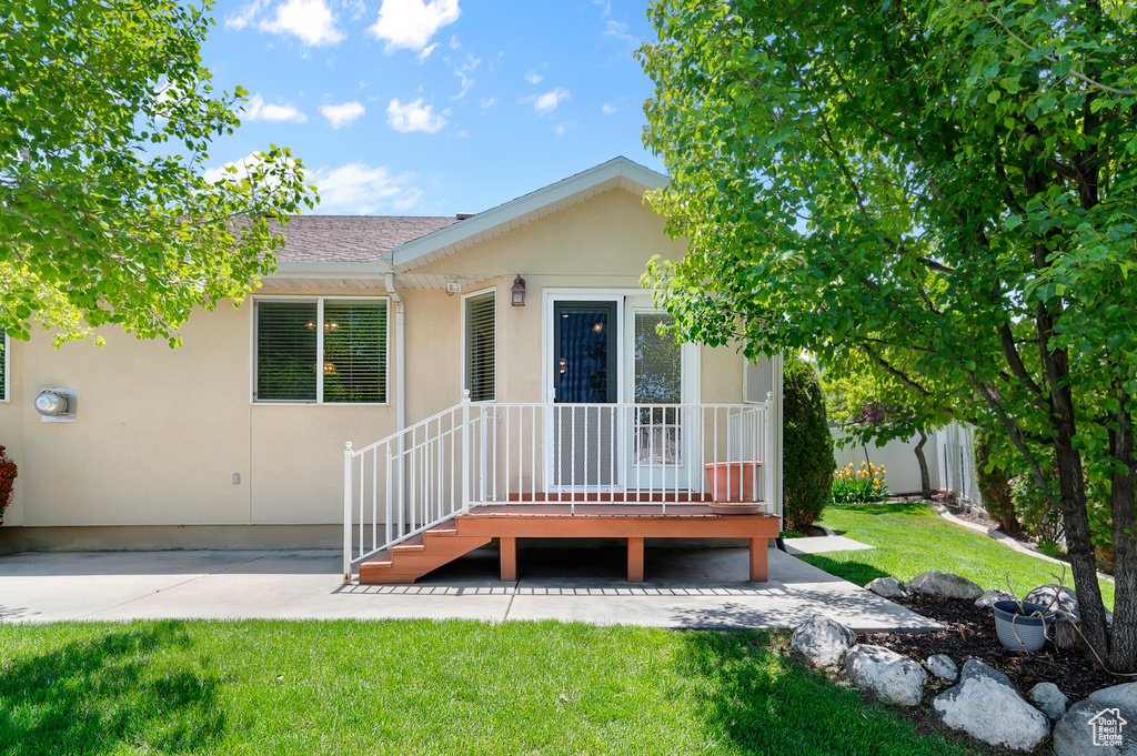 Back of property featuring stucco siding and a lawn