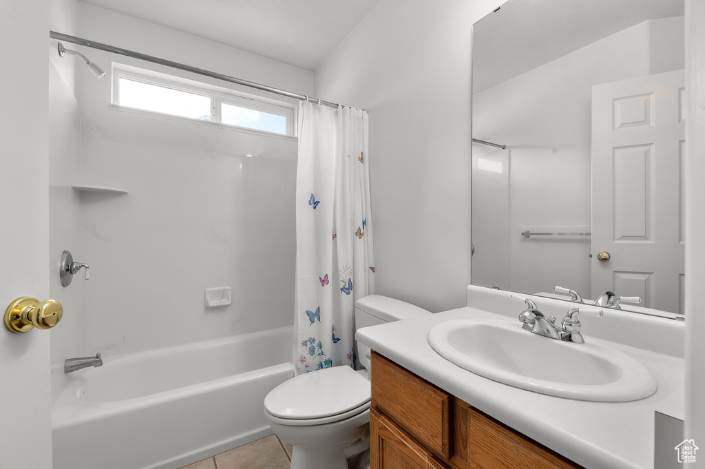 Bathroom with vanity, toilet, shower / bath combination with curtain, and tile patterned floors