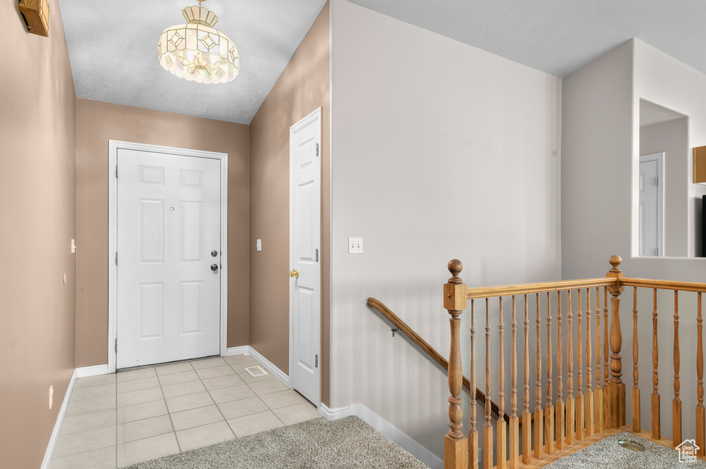 Entryway with baseboards and light tile patterned floors