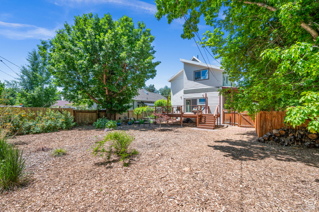 Rear view of house with a fenced backyard and a deck