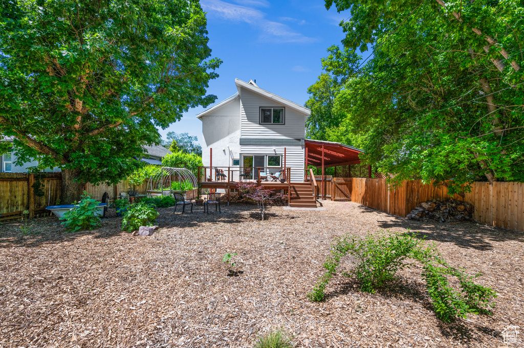 Back of property with a wooden deck and a fenced backyard