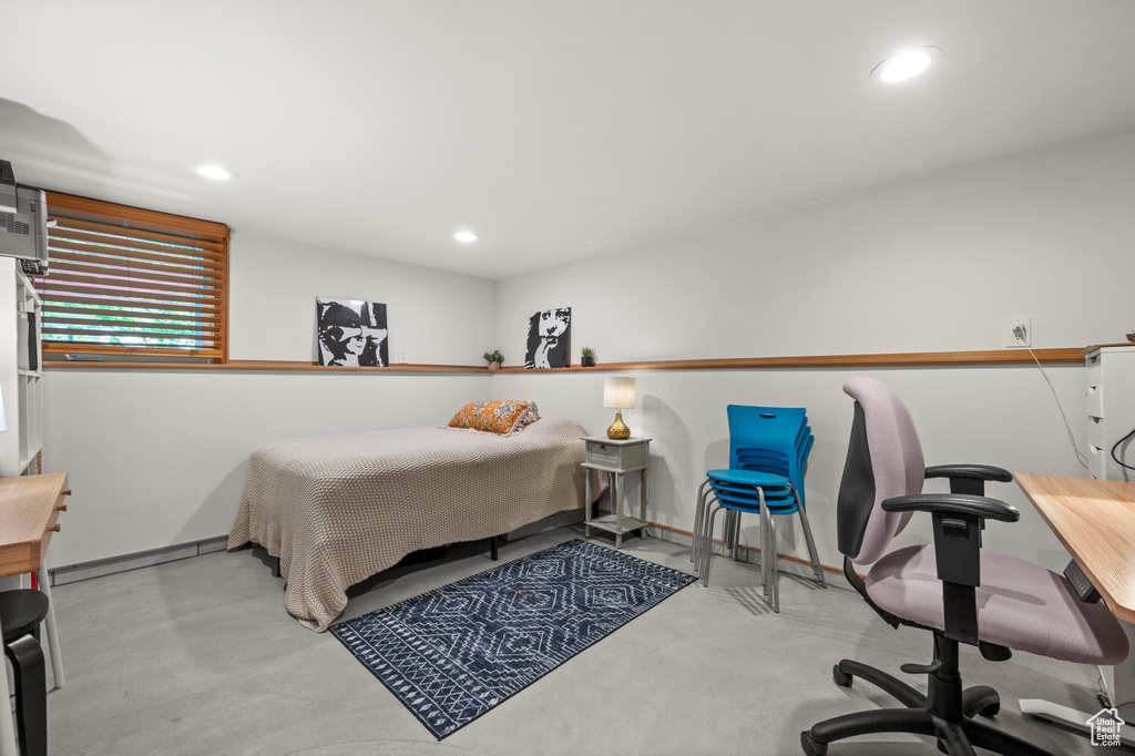 Bedroom featuring finished concrete floors, recessed lighting, and an office area