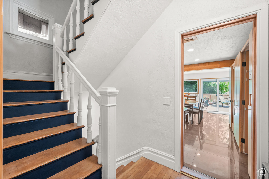 Stairs featuring wood finished floors and baseboards