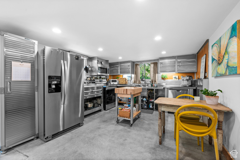 Kitchen featuring appliances with stainless steel finishes, concrete floors, and recessed lighting