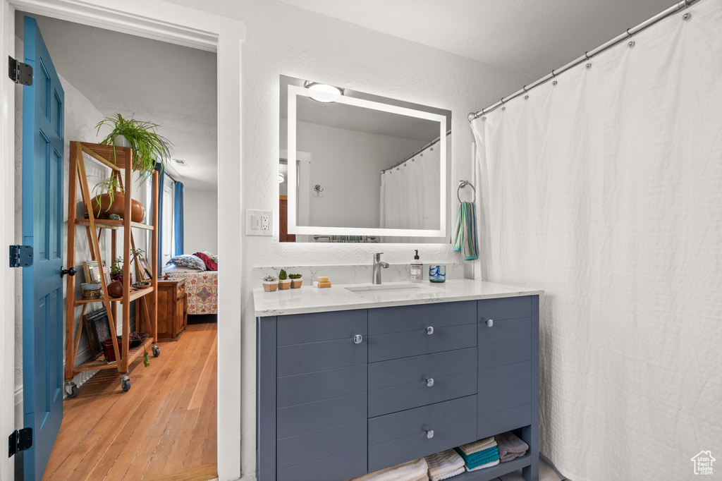 Full bathroom featuring wood finished floors and vanity