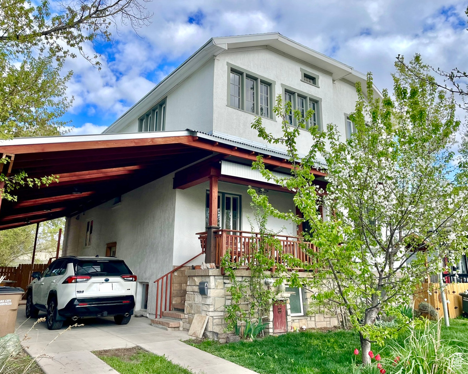 View of front facade with stucco siding and a carport