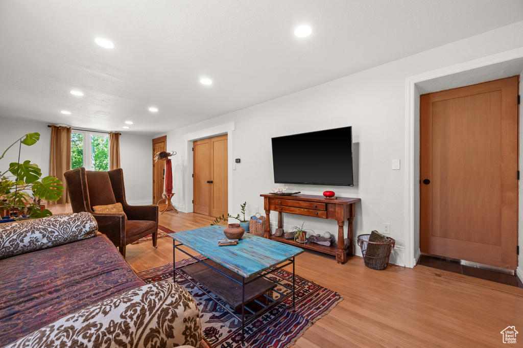 Living area with recessed lighting, light wood-style floors, and baseboards