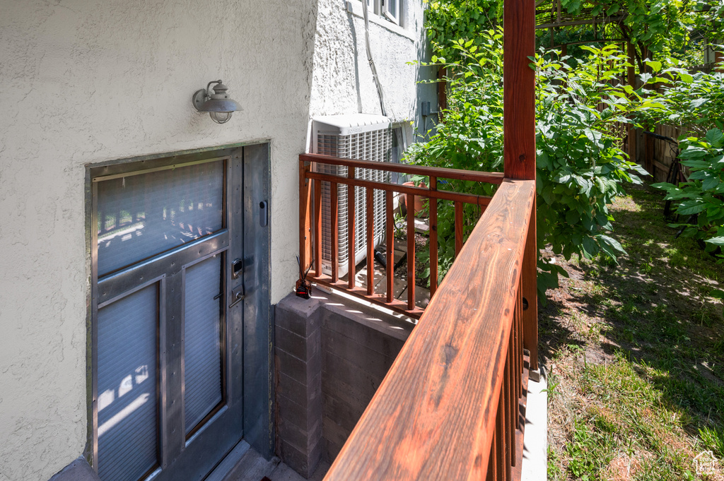 Doorway to property featuring stucco siding and central AC unit