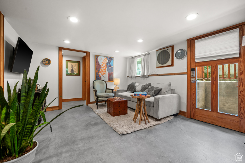 Living area featuring baseboards, recessed lighting, and finished concrete flooring