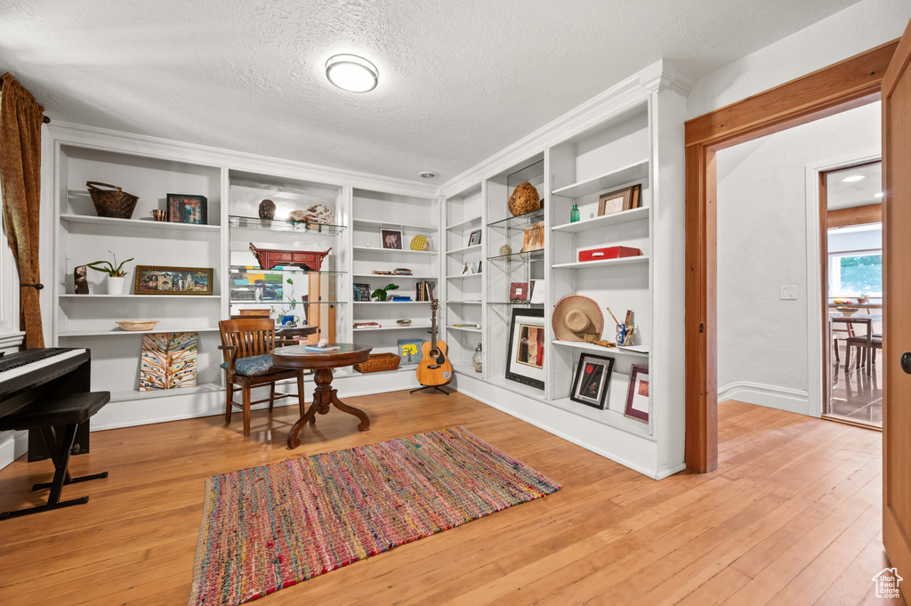 Living area featuring a textured ceiling, wood finished floors, and built in features