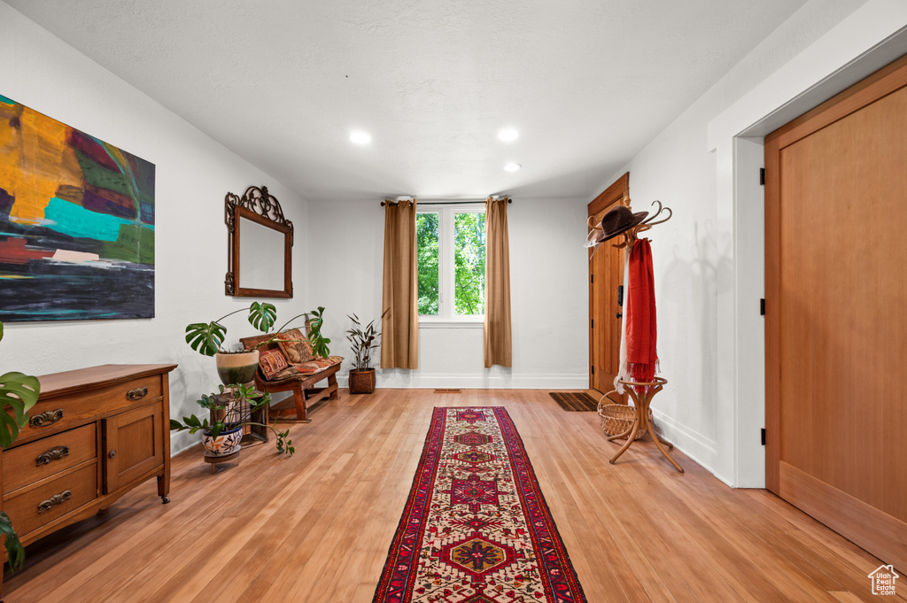 Entrance foyer with light wood finished floors, recessed lighting, and baseboards