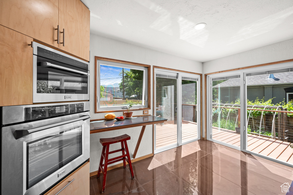 Kitchen featuring stainless steel oven and light brown cabinets