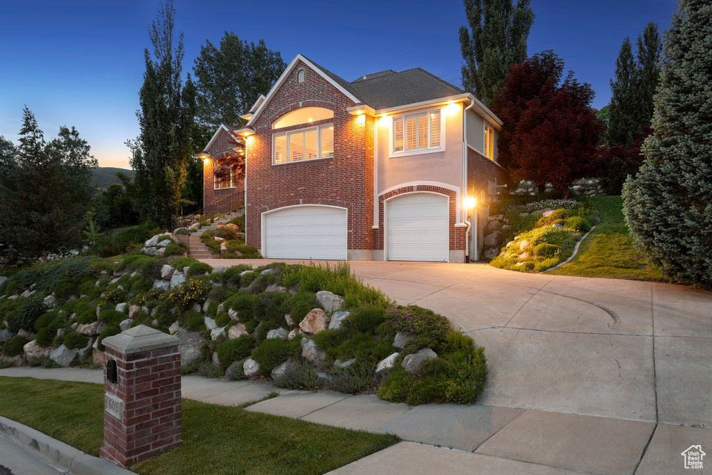 Traditional-style home with a garage, driveway, and brick siding