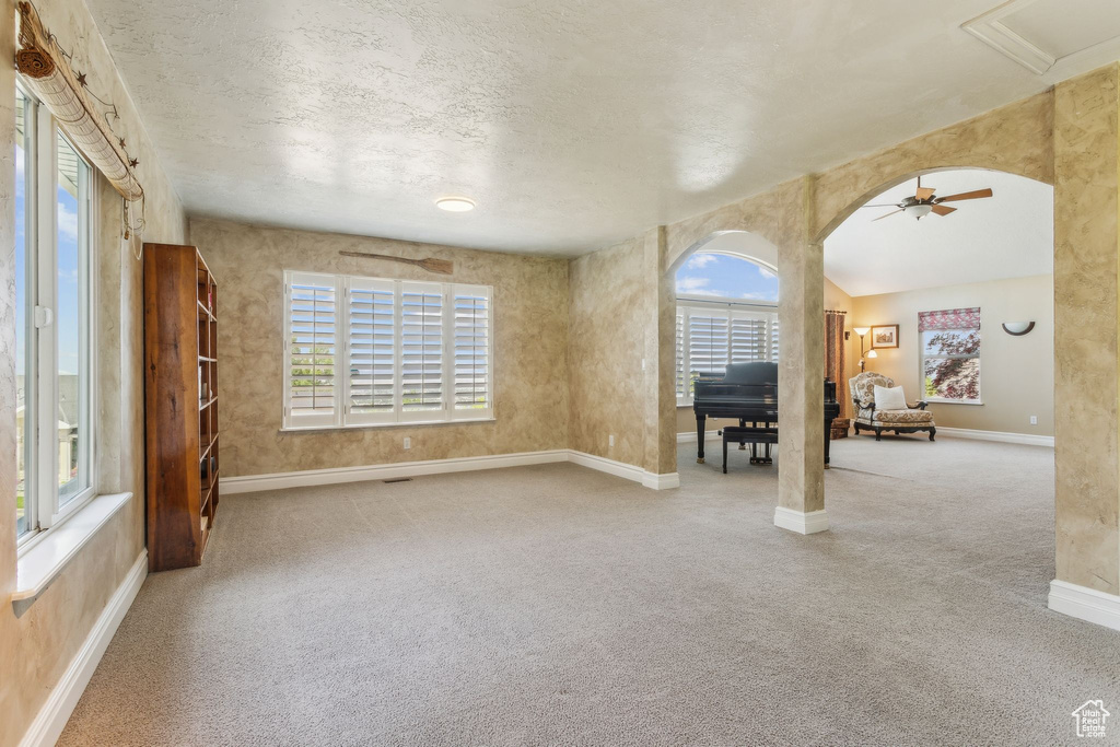 Spare room with carpet floors, baseboards, healthy amount of natural light, and a ceiling fan