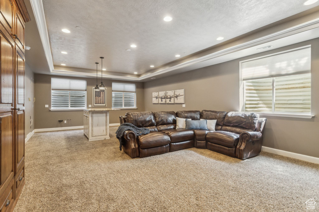 Living area featuring light colored carpet, a raised ceiling, recessed lighting, baseboards, and a textured ceiling