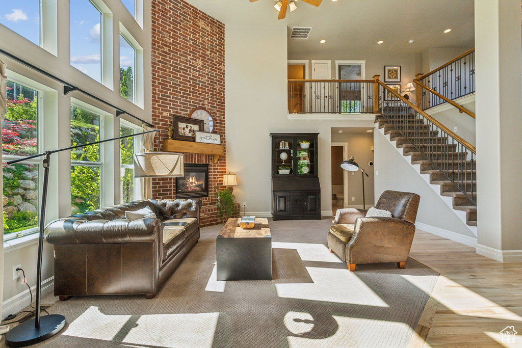 Living area with a high ceiling, plenty of natural light, baseboards, wood finished floors, and stairway