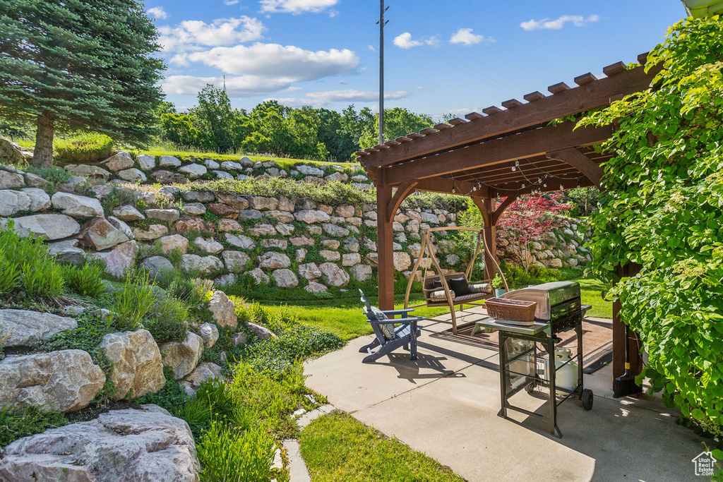View of patio featuring a pergola and a fire pit