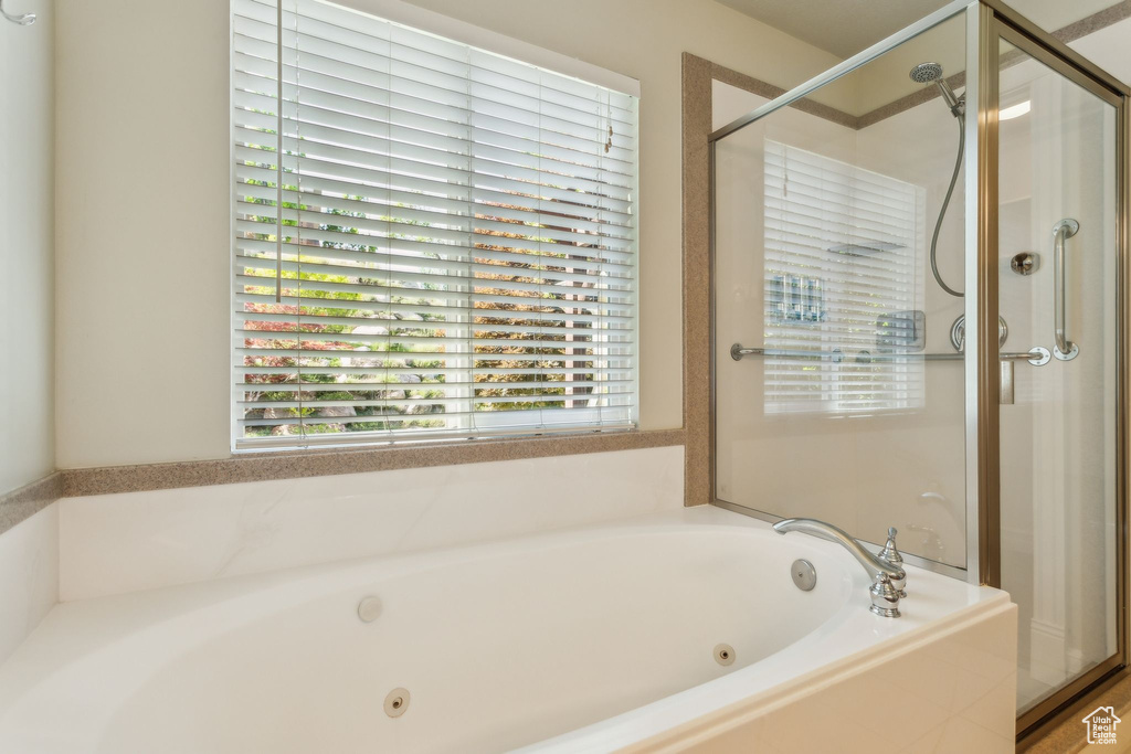 Bathroom featuring a shower stall and a whirlpool tub