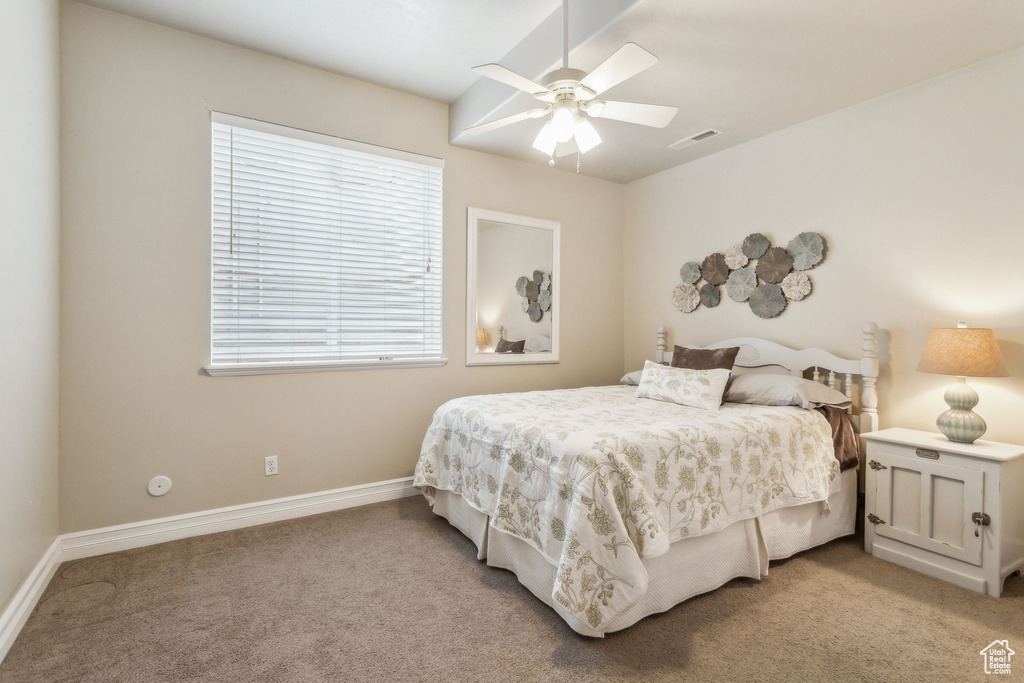 Bedroom with light carpet, baseboards, and ceiling fan