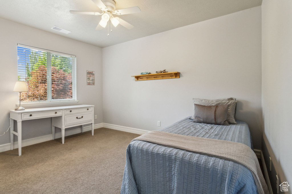 Carpeted bedroom featuring baseboards and ceiling fan