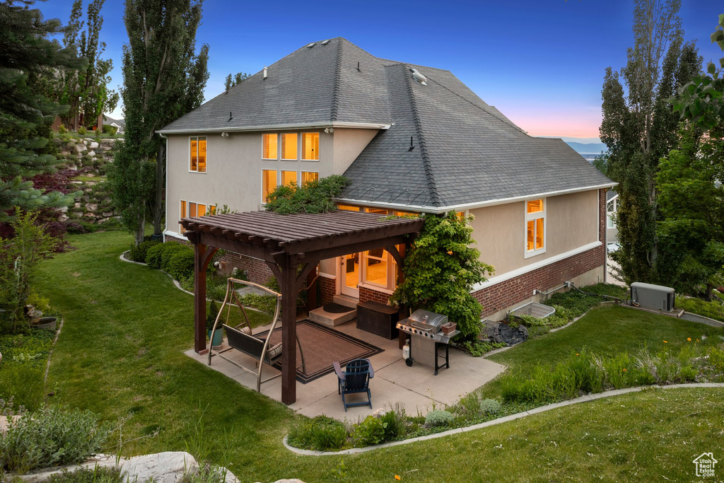 Back of property featuring a patio area, brick siding, a yard, and stucco siding