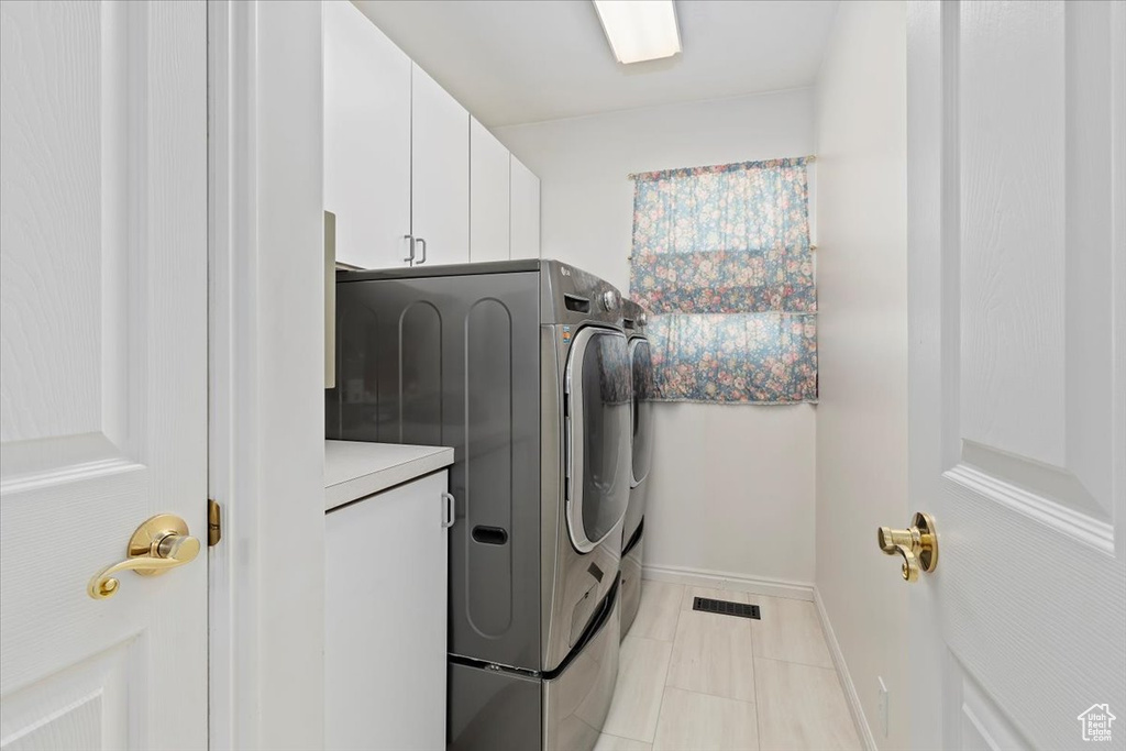 Laundry area with cabinet space, washer and dryer, and baseboards