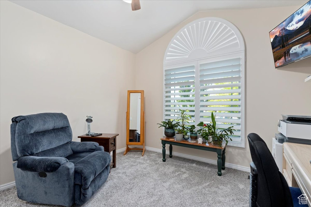 Sitting room featuring vaulted ceiling, light colored carpet, ceiling fan, baseboards, and an office area