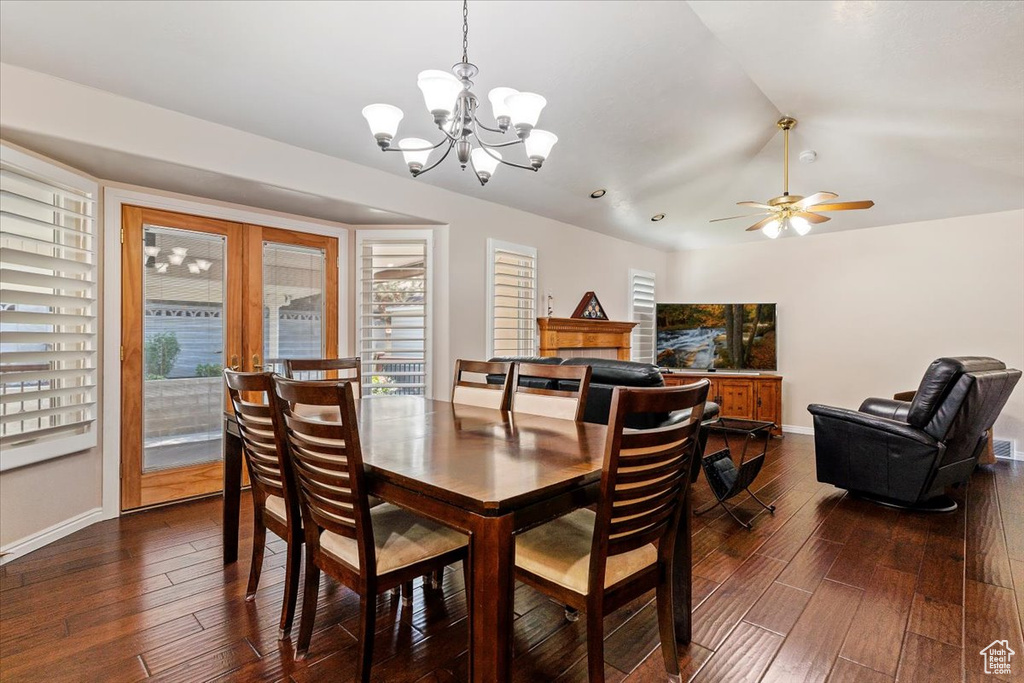Dining area featuring healthy amount of natural light, a chandelier, dark wood finished floors, and lofted ceiling