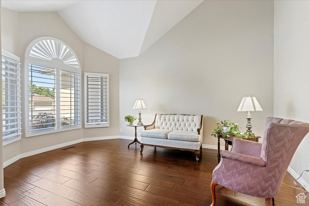Living area featuring wood finished floors, baseboards, and high vaulted ceiling
