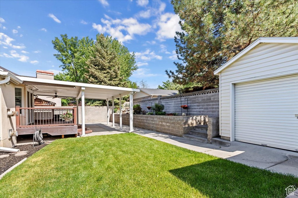 View of yard with a ceiling fan and a patio