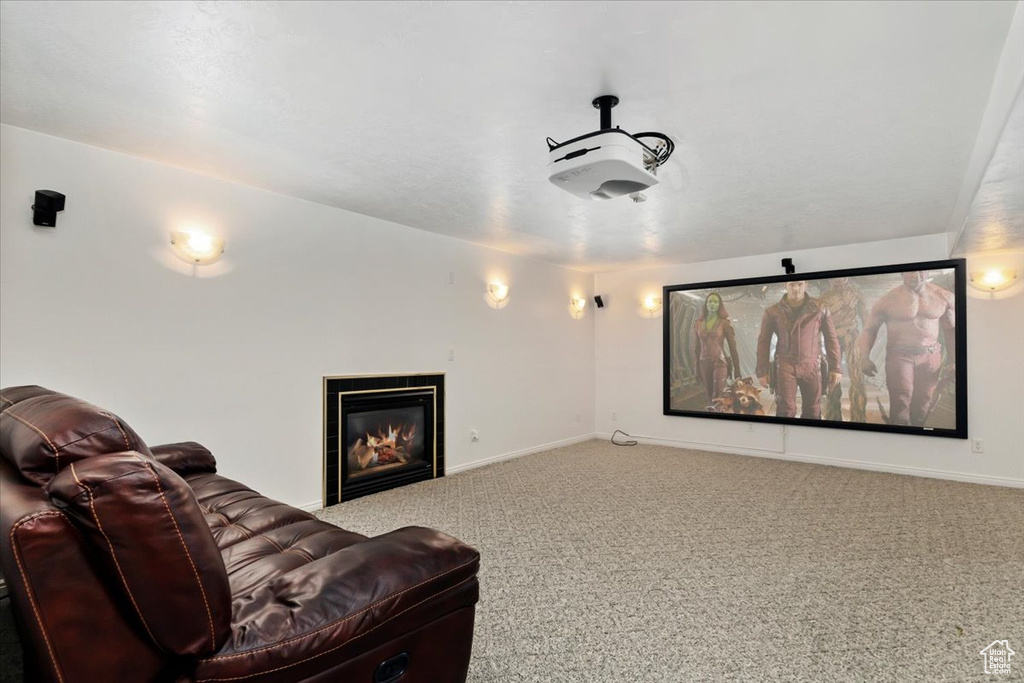 Home theater room featuring carpet, baseboards, and a tile fireplace