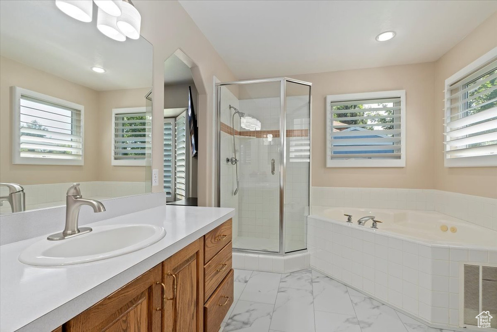 Full bath featuring a bath, vanity, a shower stall, recessed lighting, and marble finish flooring