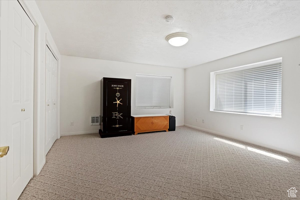 Unfurnished bedroom featuring light carpet and baseboards