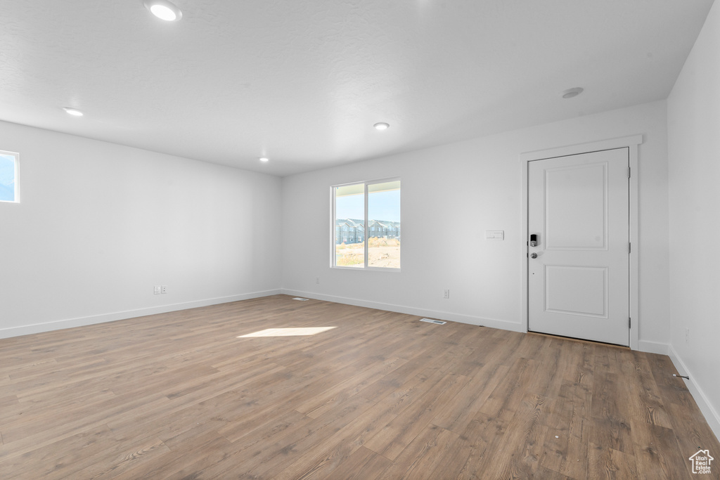 Spare room featuring light wood-type flooring, baseboards, and recessed lighting